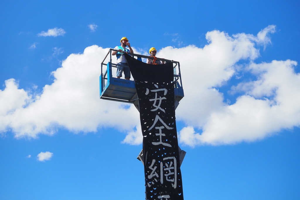 高空作業車上的工會成員垂放「安全網」黑色布條