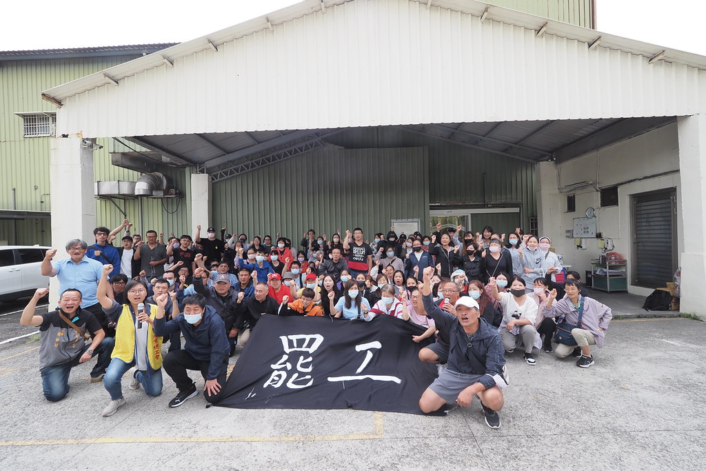 乖乖工會會員在中壢廠門口拉起罷工布條合影，舉拳慶祝罷工落幕